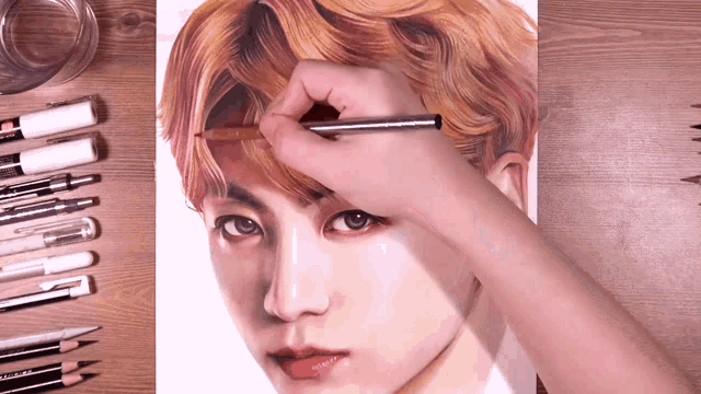 a person is drawing a portrait of a boy with a pencil
