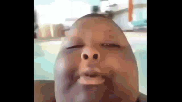 a close up of a man making a funny face with his eyes closed and his mouth open .