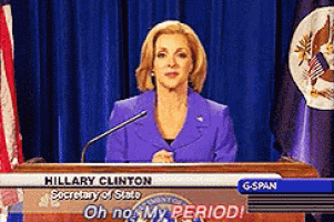 a woman in a purple suit stands at a podium with hillary clinton secretary of state on it