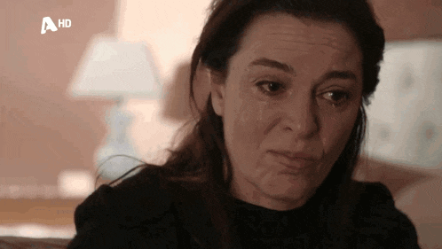 a close up of a woman 's face with a tear running down her cheek .