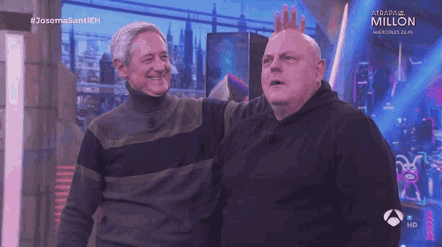 two men are standing next to each other on a television screen that says #josemasantieh