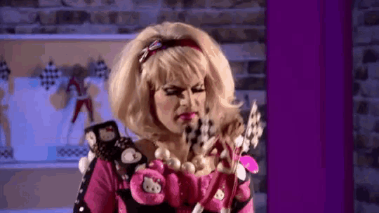 a woman is wearing a hello kitty costume and holding a hello kitty doll .
