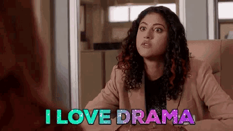 a woman is sitting at a table with the words `` i love drama '' written above her .