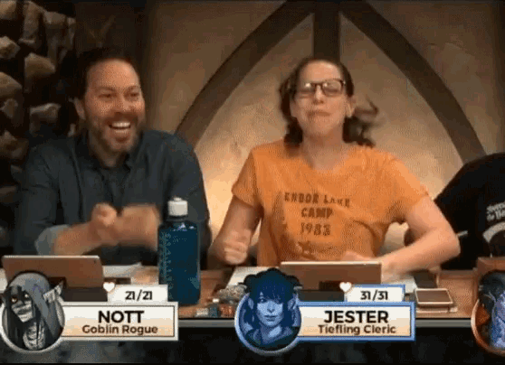 a man and a woman are sitting at a table with a sign that says nott goblin rogue on it .
