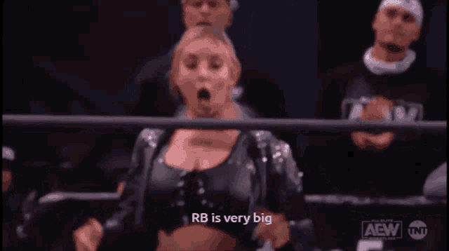 a woman is sitting in a wrestling ring with her mouth open .