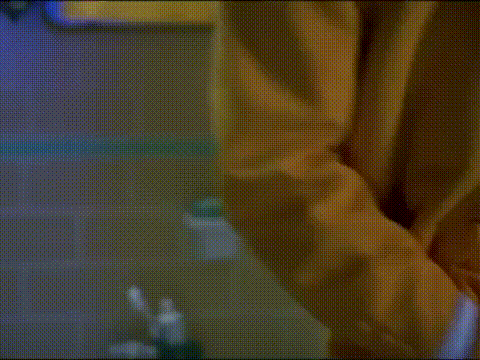 a man in a yellow suit is holding a piece of tissue