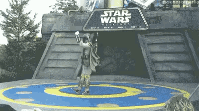 a man in a star wars costume stands in front of a sign