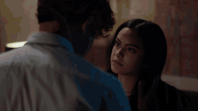 a man with a beard is being punched in the face by a woman in a leather jacket .