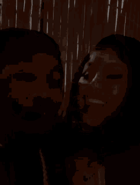a man and a woman are standing next to each other in a dark room .