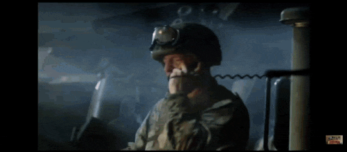 a man in a military uniform is talking on a cell phone