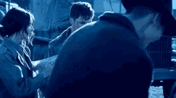a group of people standing next to each other in a dark room .