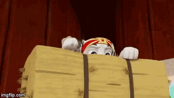 a cartoon character is peeking out from behind a large wooden box .