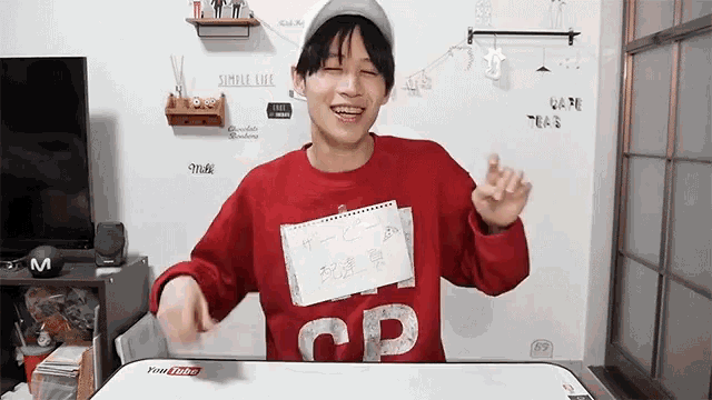 a young man wearing a red sweater with the letter cd on it