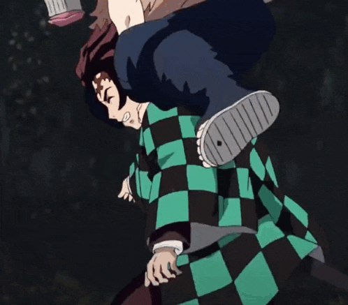 a person wearing a black and green plaid shirt is standing on another person 's feet