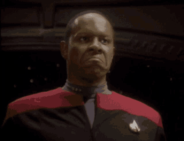 a man in a red and black uniform with a star trek logo on his jacket