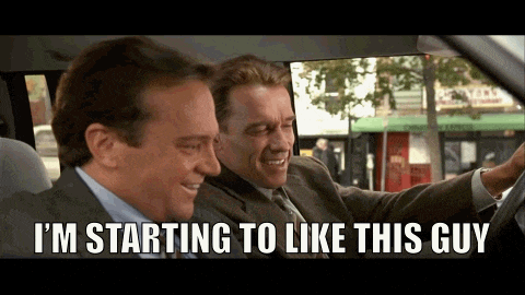 two men in suits are sitting in a car and one of them is saying i 'm starting to like this guy