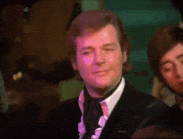 a man in a suit and tie is smiling in front of a crowd