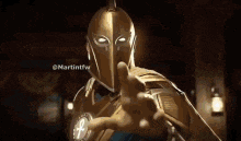 a man in a helmet and armor is pointing at the camera .