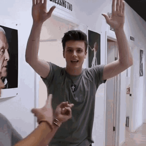 a man with his arms in the air in front of a sign reading dressing two
