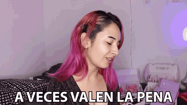 a woman with pink hair and the words a veces valen la pena