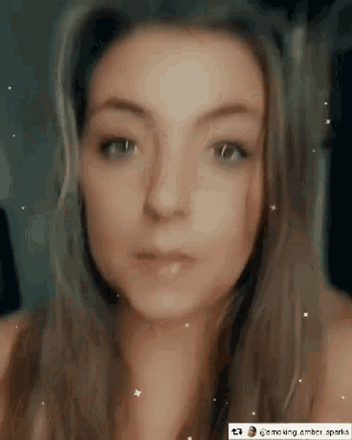 a close up of a woman 's face with sparks coming out of her mouth .