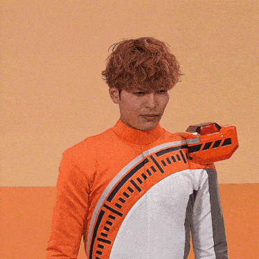 a man wearing an orange and white outfit has a red object on his arm