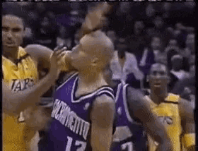 a basketball player with the number 12 on his jersey is being fouled