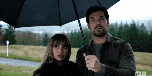 a man and a woman under an umbrella with the letters cw on the bottom