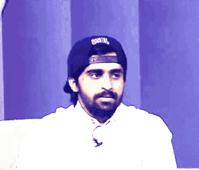 a man with a beard wearing a hat that says ' gsbl ' on it