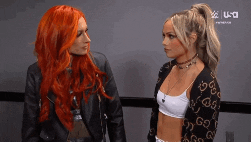 two women with red hair are standing next to each other in front of a screen that says usa