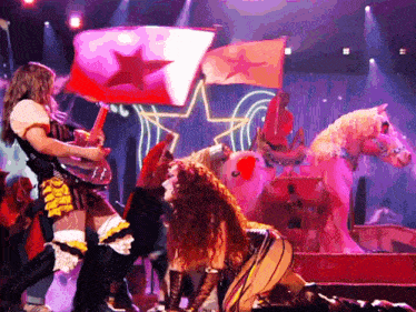 a woman holding a flag with a red star on it stands in front of a horse