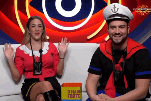 a man in a sailor costume sits next to a woman in a big brother outfit