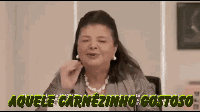 a woman with a pearl necklace is smiling with the words aquele carnezinhogostoso above her