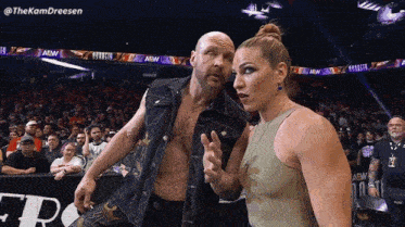 a man and a woman are standing next to each other in a wrestling ring with a aew banner in the background