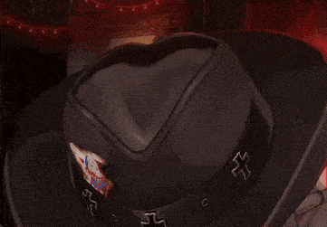a close up of a person wearing a cowboy hat with a cross on it