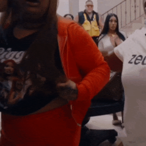 a woman in a red hoodie is holding a white shirt with the word zel on it