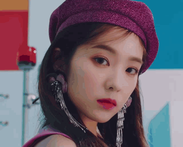 a close up of a girl wearing a purple hat and earrings