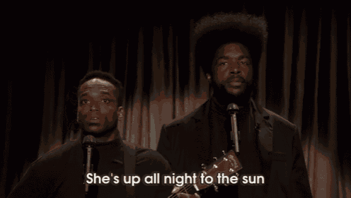 a man singing into a microphone with the words she 's up all night to the sun
