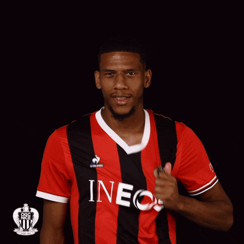 a man wearing a red and black jersey that says ineos