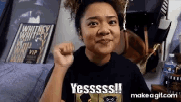 a woman is making a funny face while wearing a black shirt that says yesssss !