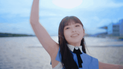 a woman in a blue and white dress is smiling with her arms outstretched