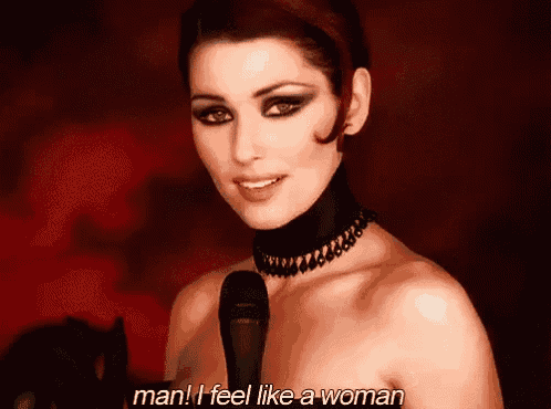 a woman singing into a microphone with the words man i feel like a woman written below her