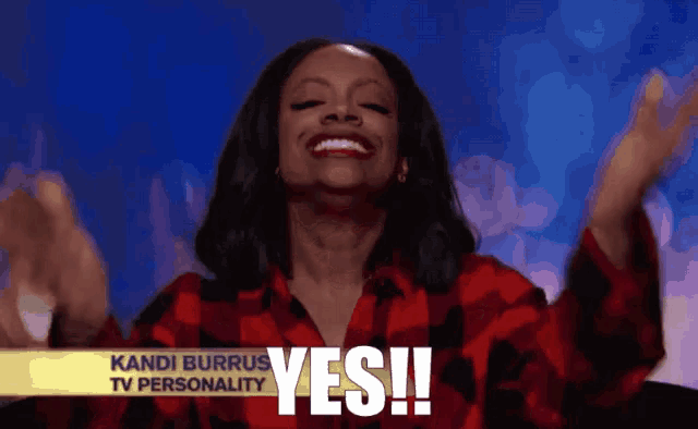 a woman in a red plaid shirt is smiling with the words yes behind her