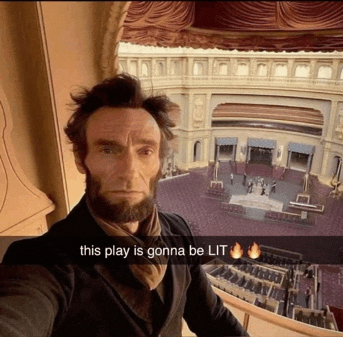 a man dressed as abraham lincoln takes a selfie in front of an auditorium