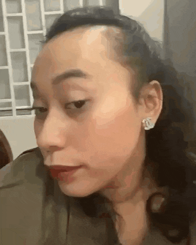a close up of a woman 's face with a shaved head .