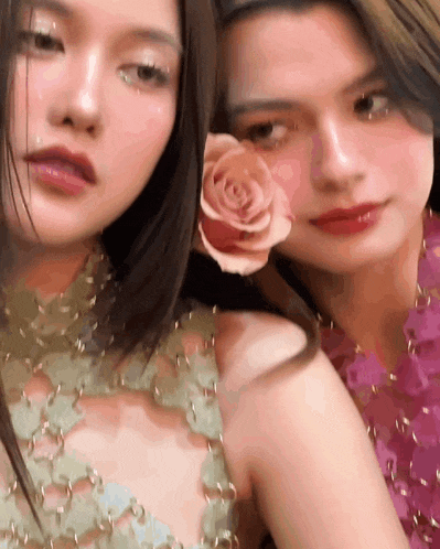 two women are posing for a picture and one has a rose in her hair