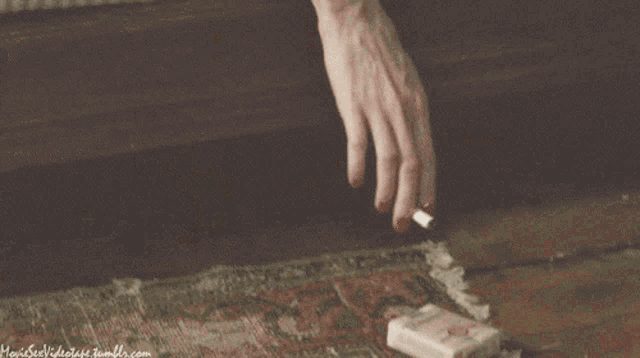 a close up of a person 's hand holding a piece of paper with a website written on the bottom of the image