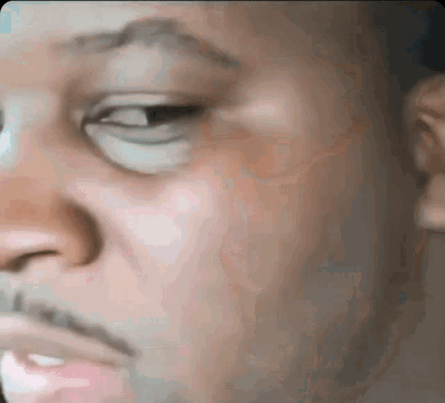 a close up of a man 's face with his eyes closed and his mouth open