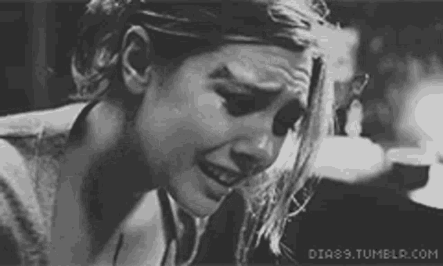 a black and white photo of a woman crying with tears coming out of her eyes .