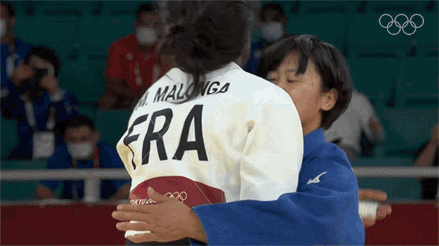 two women hugging with one wearing a jersey that says era